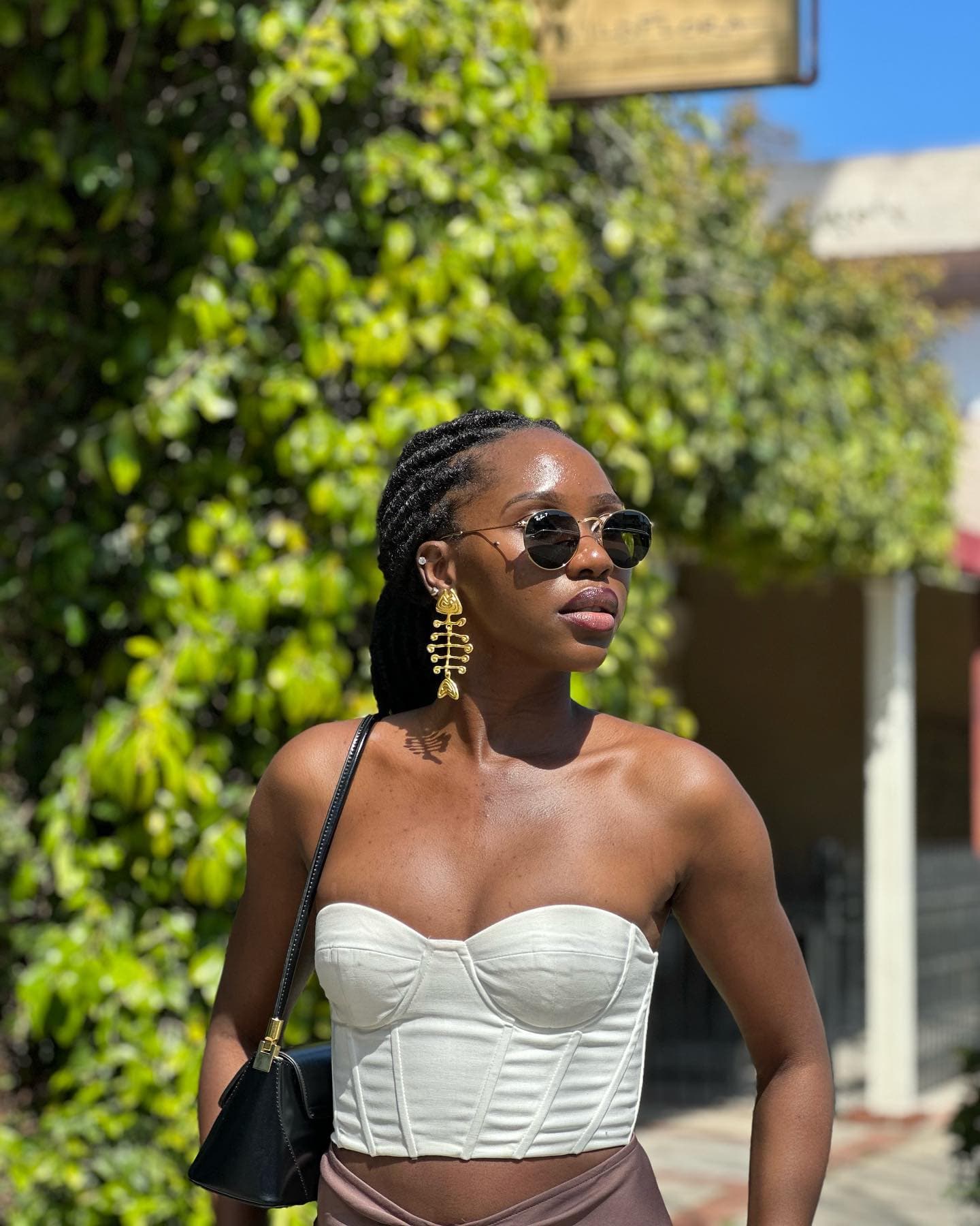 Confident solo traveller in white corset top on a sunny street